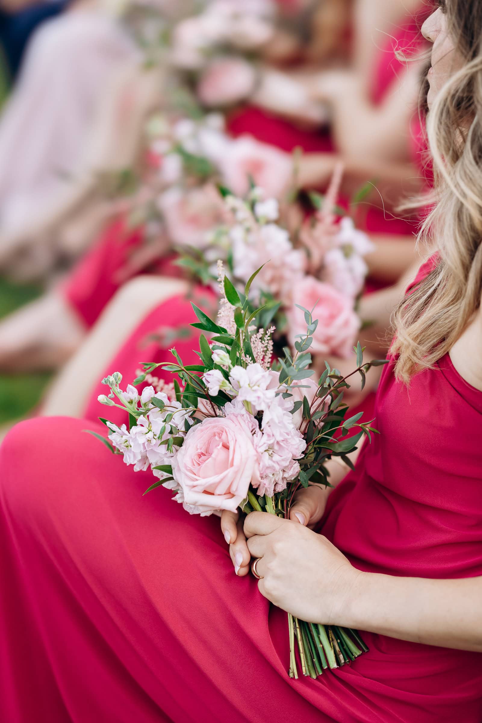 Close-up of bridesmaids in magenta dresses holding bouquets of pink roses and greenery, Hudson House, Jersey City, NJ.