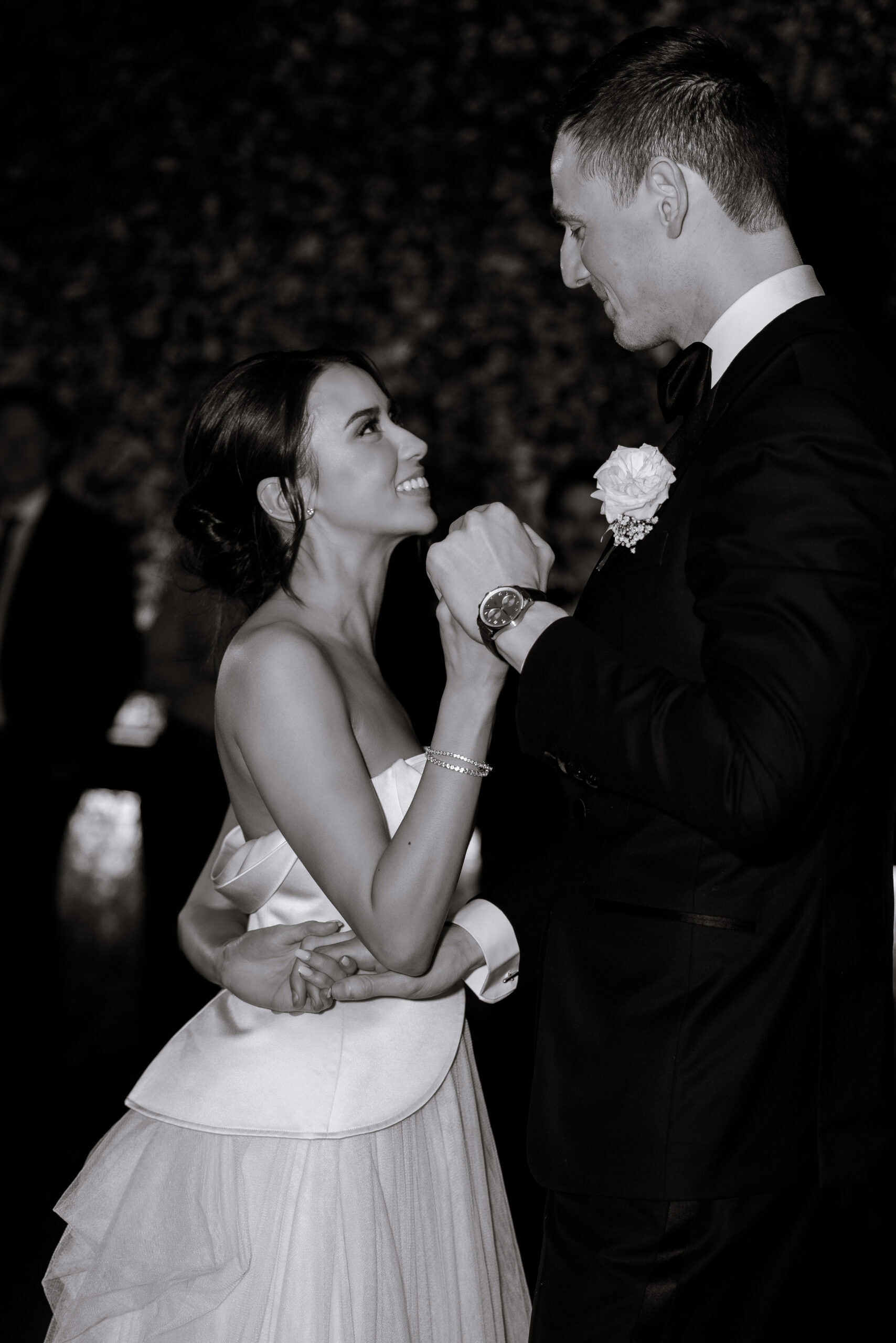 Black-and-white wedding portrait of a couple dancing at The Foundry, the bride in a strapless satin gown looking up at her partner in a black tuxedo.