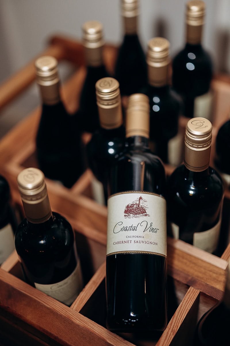Close-up of Coastal Vines Cabernet Sauvignon wine bottles with gold caps arranged in a wooden crate at The Stone House, Warren, NJ.