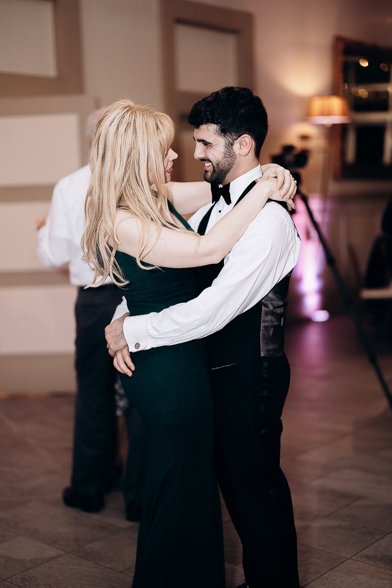 Man and woman embracing and dancing closely in a softly lit ballroom at The Stone House, Warren, NJ.