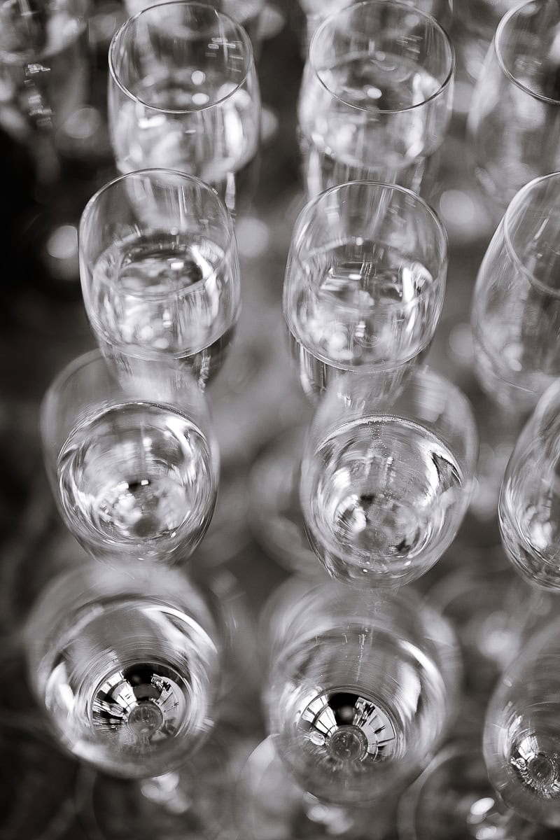 Overhead view of grouped champagne flutes with bright reflections and soft bokeh at The Switch House by Cescaphe, Philadelphia, PA.
