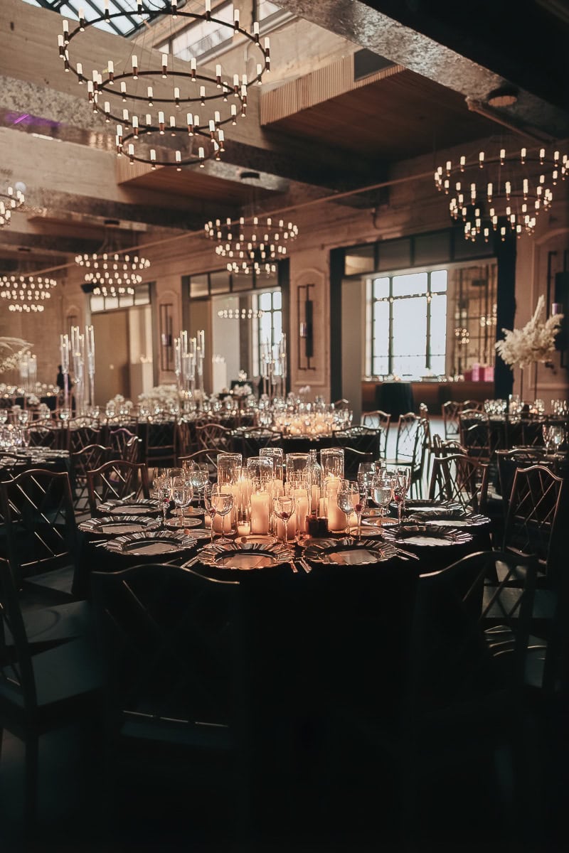 Candlelit wedding reception with glass hurricanes, crystal stemware, and ring chandeliers at The Switch House by Cescaphe, Philadelphia.