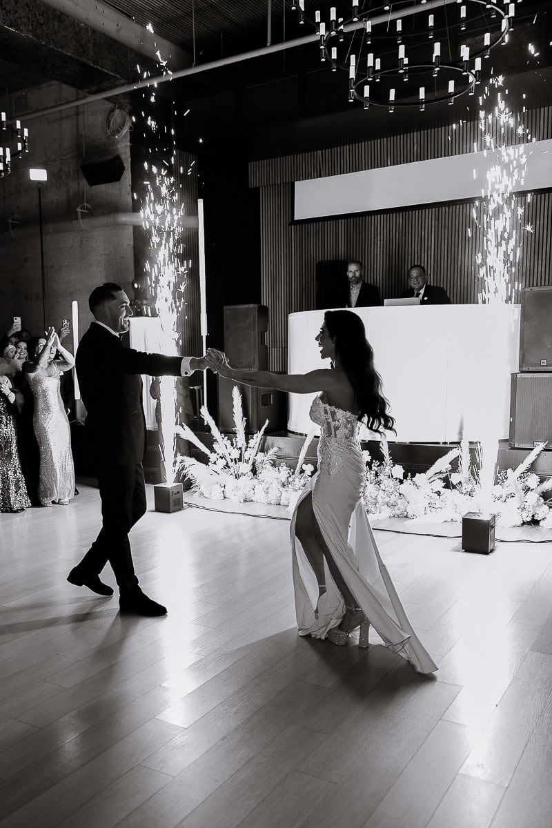 Black-and-white first dance with indoor sparklers, floral aisle, and DJ booth at The Switch House by Cescaphe, Philadelphia.