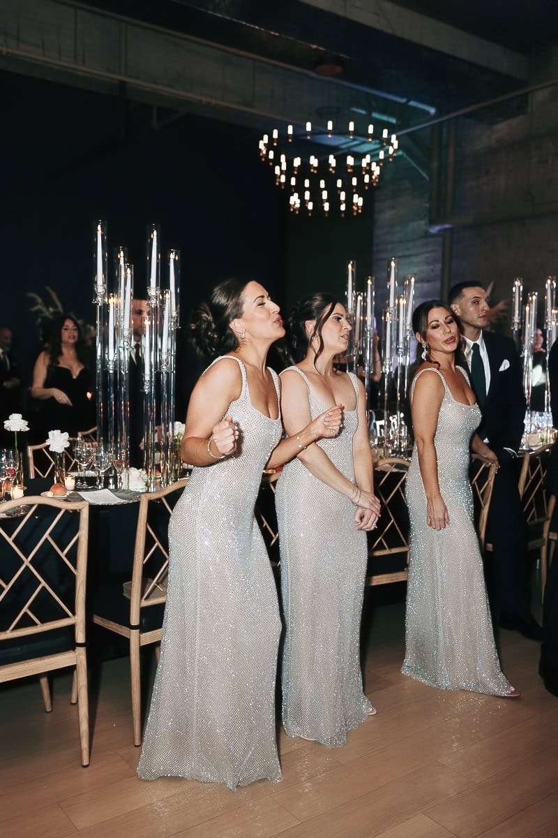 Three women in silver sequin gowns sway beside candlelit tables at The Switch House by Cescaphe, Philadelphia, PA.