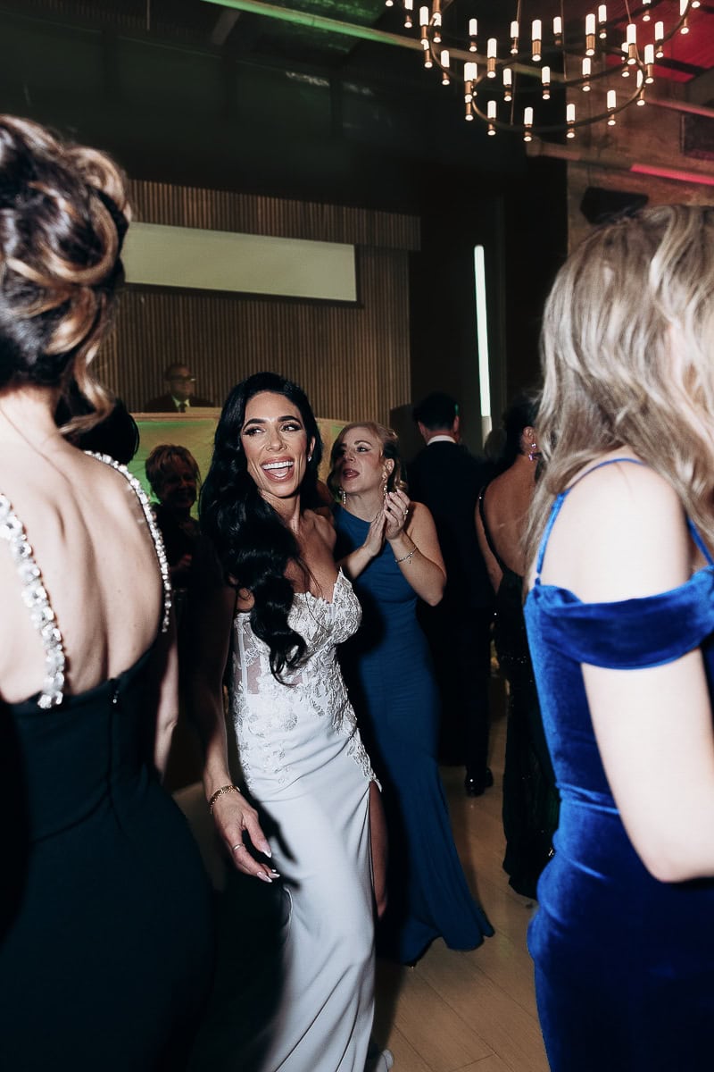 Bride in lace gown with thigh-slit dances among guests at The Switch House by Cescaphe, Philadelphia, PA.