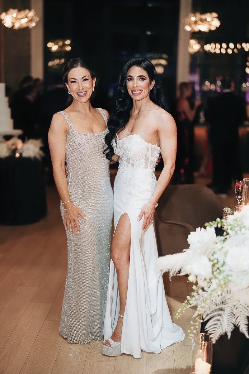 Two women in silver and white gowns at a candlelit reception with florals and chandeliers at The Switch House by Cescaphe, Philadelphia.