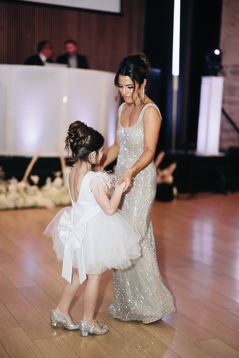Woman in silver sequin gown dances with girl in tulle dress and bow on parquet floor at The Switch House, Philadelphia.