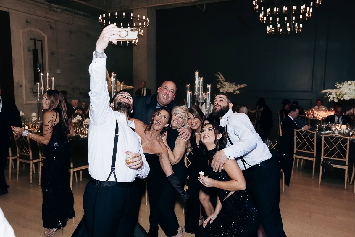 Black‑tie guests take a selfie amid candlelit tables and chandeliers at The Switch House by Cescaphe, Philadelphia, PA.
