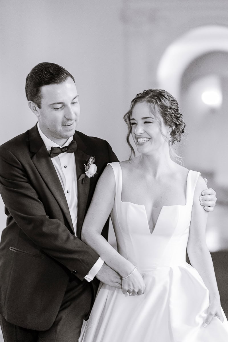 Bride in sculpted white gown and groom in black tuxedo share an intimate moment at Westchester Country Club, Rye, NY.