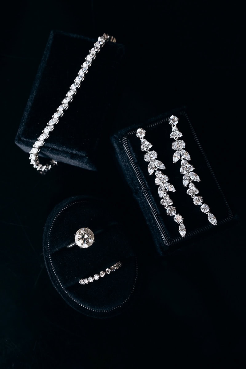 Close-up of diamond tennis bracelet, drop earrings, and two rings on black velvet displays at Westchester Country Club, Rye, NY.